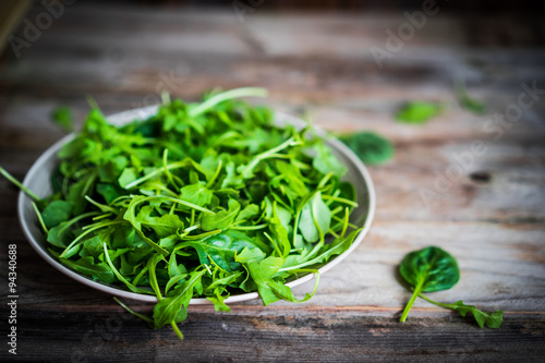 Fresh arugula and spinach salad on rustic background