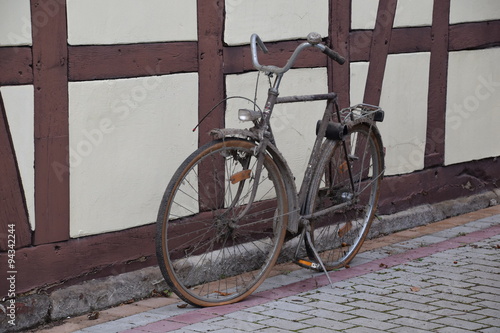 Rostiges Fahrrad vor Fachwerkhaus