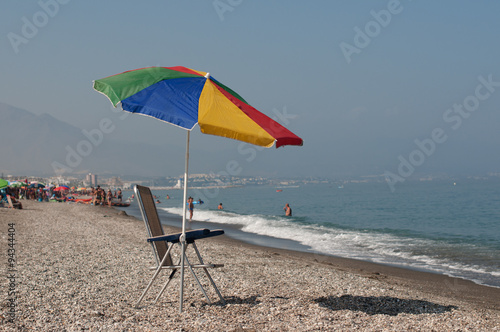 Fototapeta Naklejka Na Ścianę i Meble -  Typical umbrella and chair on spanish rocky beach