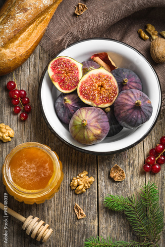 Fototapeta Naklejka Na Ścianę i Meble -  Holiday appetizer food on table: fresh figs, walnuts, honey and bread on wooden background