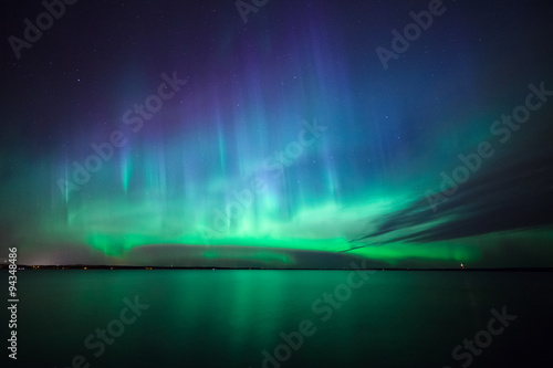 Northern lights over lake in finland photo