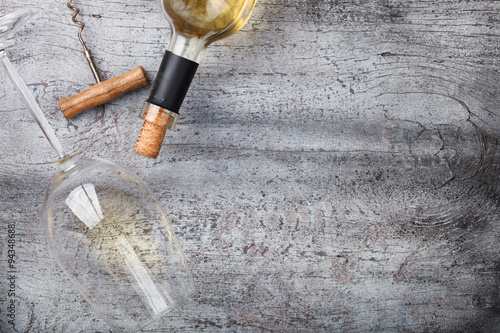 Bottle of white wine,a corkscrew,a glass,on wooden background.Copy space. selective focus.