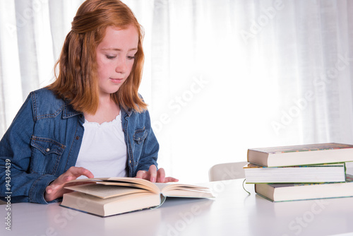 young redhead girl reading in books