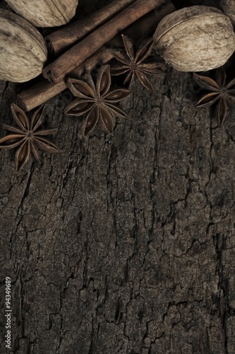 walnuts star anise and cinnamon sticks on a cork board