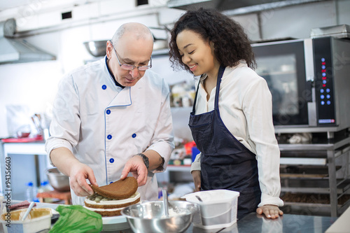 young girl learns to bake cakes with porfessionalnym baker