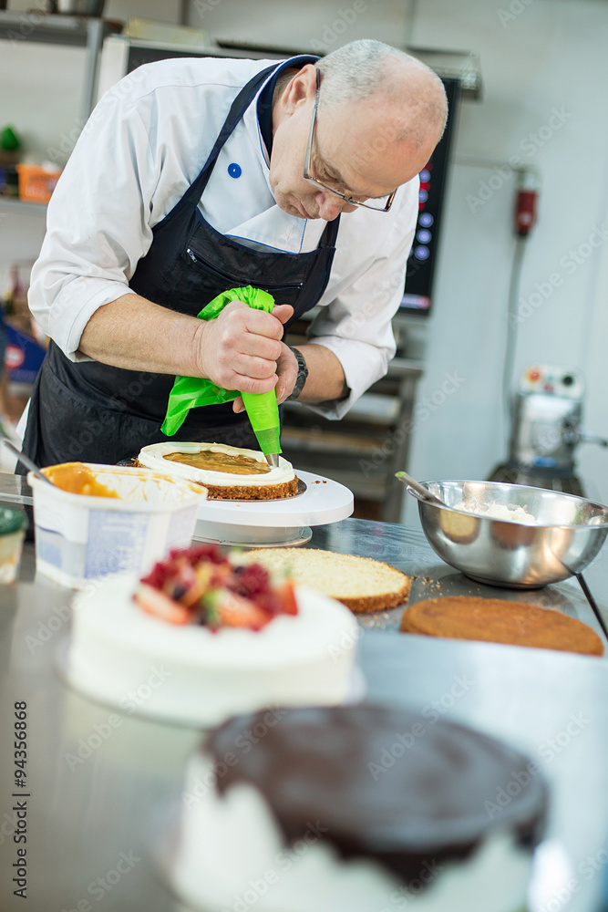 Baker prepares a cake and eclairs Baker prepares a cake and eclairs