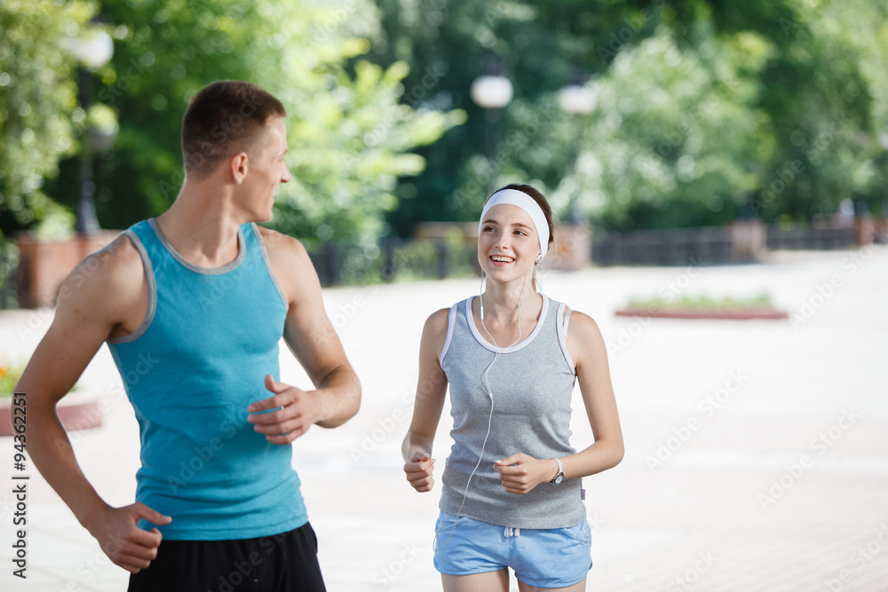 Young couple jogging in park at morning. Health and fitness. Young couple jogging in park at morning. Health and fitness.