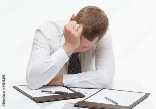 Wallpaper Mural Weary clerk sitting at the table and bending  his head, white ba Torontodigital.ca