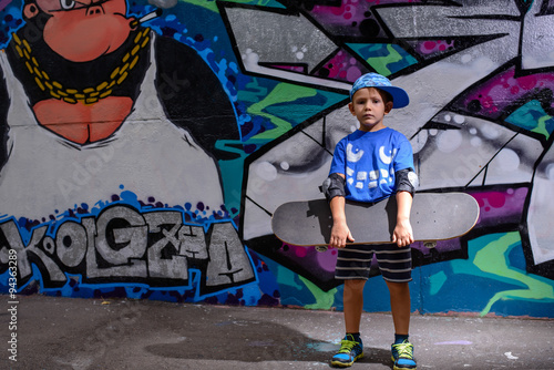 Handsome little boy holding his skateboard