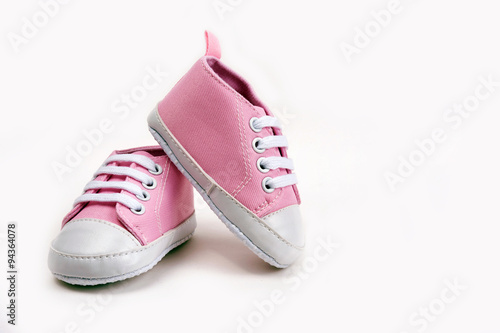 Pink baby girl shoes on a wooden floor outdoors photo