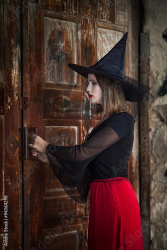 Witch opening the door of the haunted house