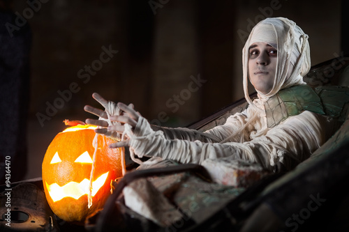 Mummy attack on a Jack O' Lantern from an old broken car