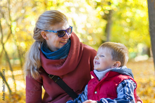 Mother and son smiling at the park in autumn