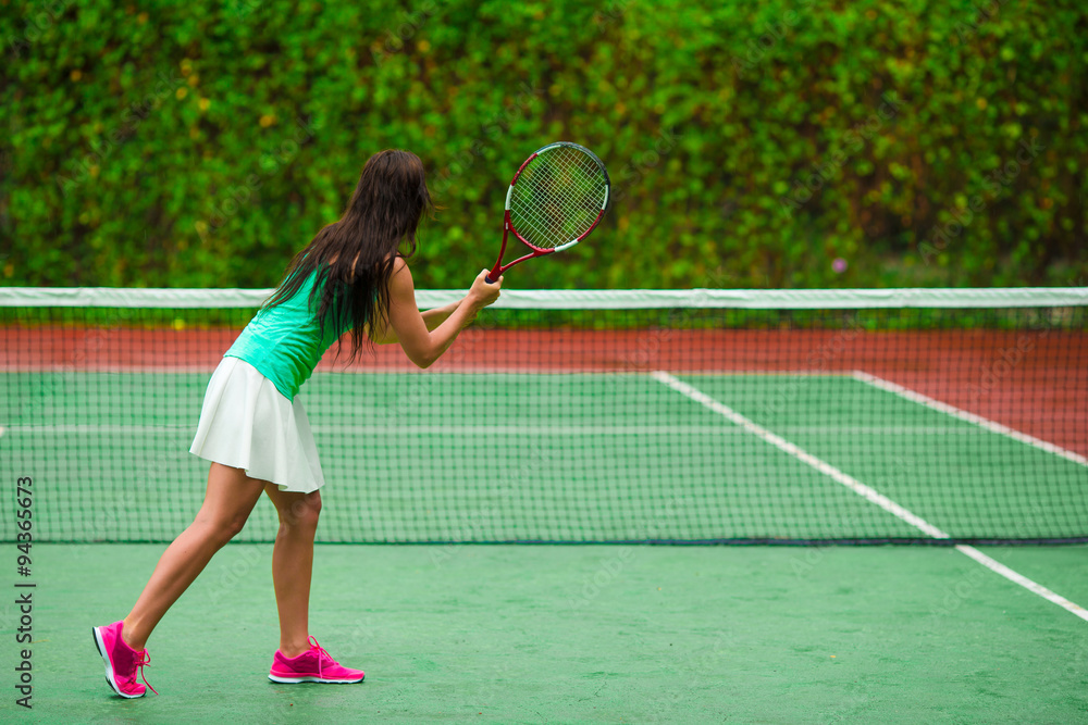 Young active sporty woman playing tennis on tropical vacation