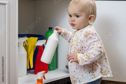 Little girl playing with household cleaners