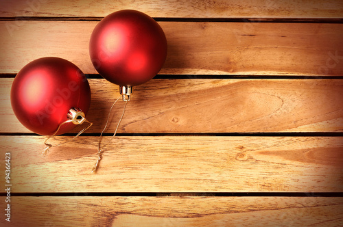 Two red balls Christmas decoration on a wooden table top