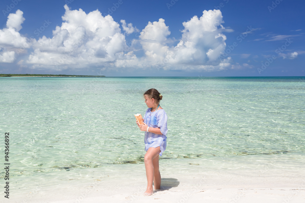 beautiful charming stylish little girl walking along the beach and tranquil inviting ocean , holding bread in her hands and feeding the fish beautiful charming stylish little girl walking along the beach and tranquil inviting ocean , holding bread in her hands and feeding the fish