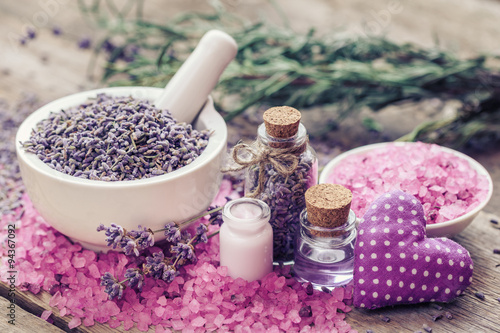 Dry lavender flowers in mortar, sea salt, cream, essential oil a