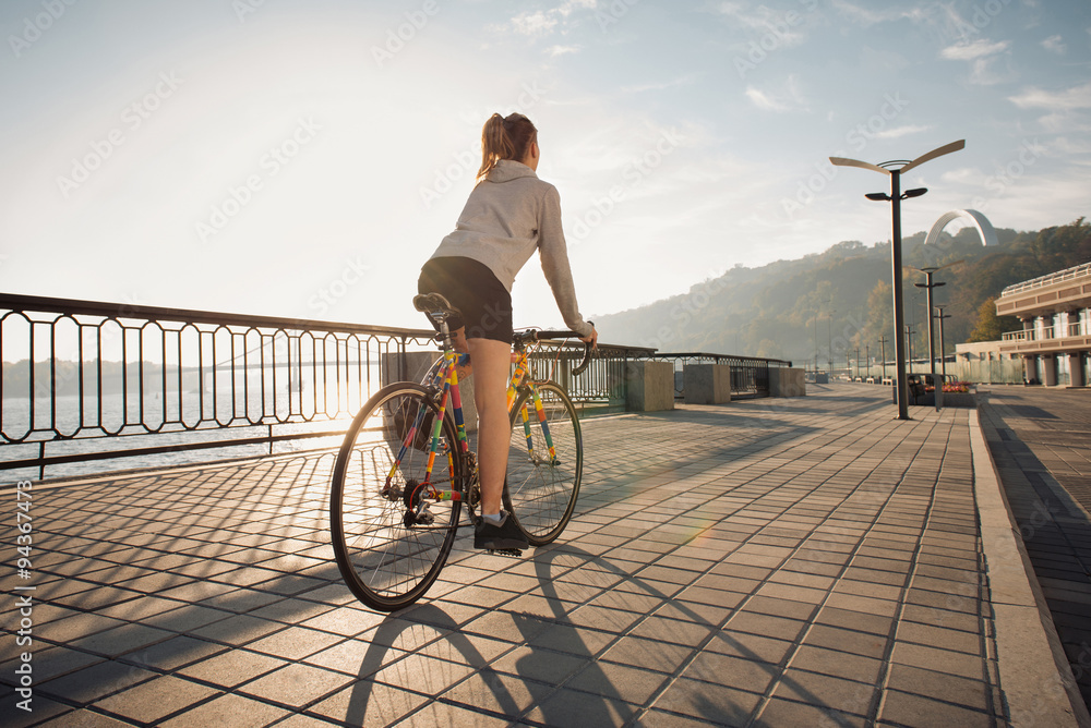 Fototapeta premium Young woman cycling in the morning city