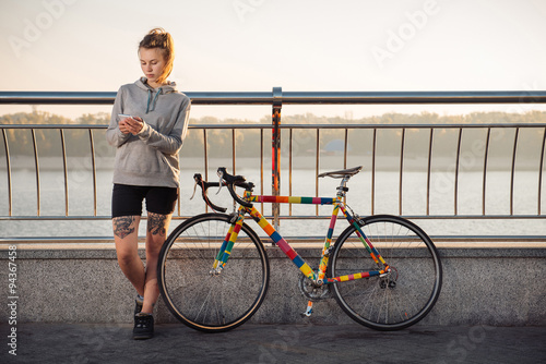 Young woman and bike in city