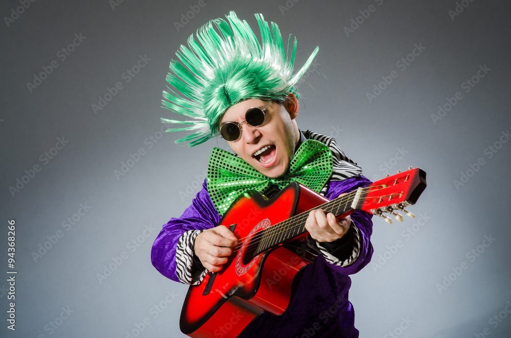 Fototapeta premium Funny man playing guitar in musical concept