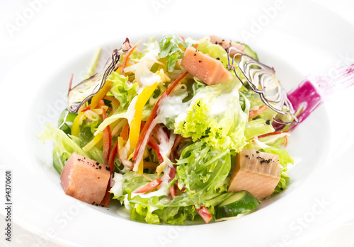 pink salmon salad and vegetables on a table in a restaurant