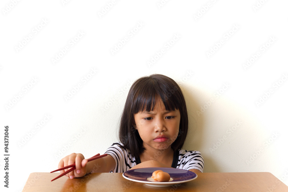Bored children girl with red chopsticks sitting at the table Bored children girl with red chopsticks sitting at the table
