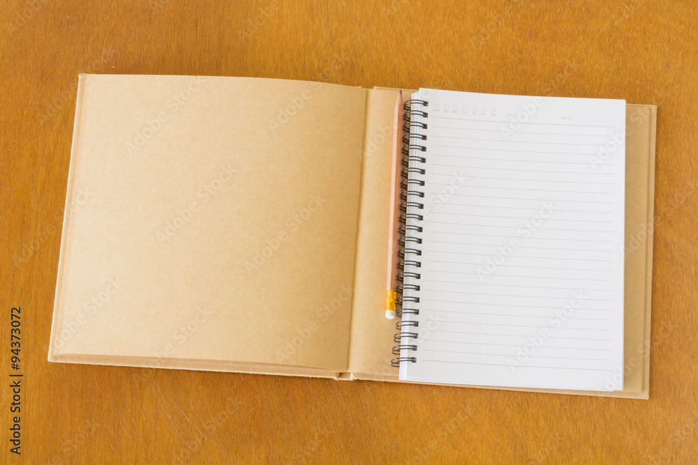 Blank notebook and pencils on the wooden table. View from above