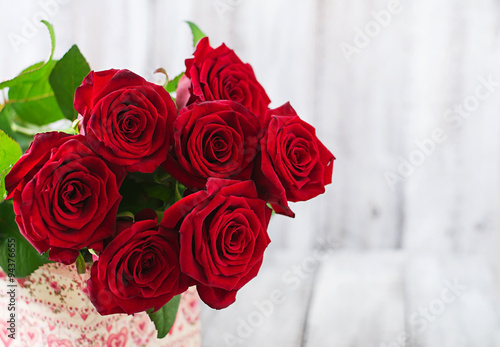 Bouquet of red roses on a light wooden background