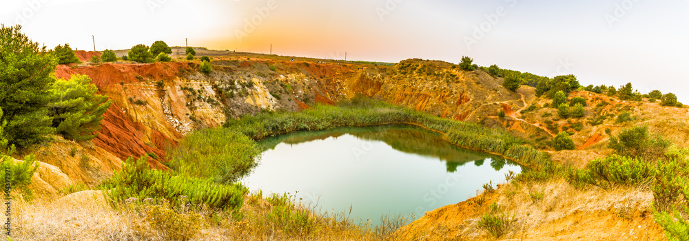 Naklejka premium red soils around the lake in bauxite quarry