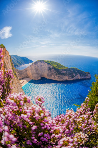 Fototapeta Naklejka Na Ścianę i Meble -  Navagio beach with shipwreck and flowers against sunset, Zakynthos island, Greece