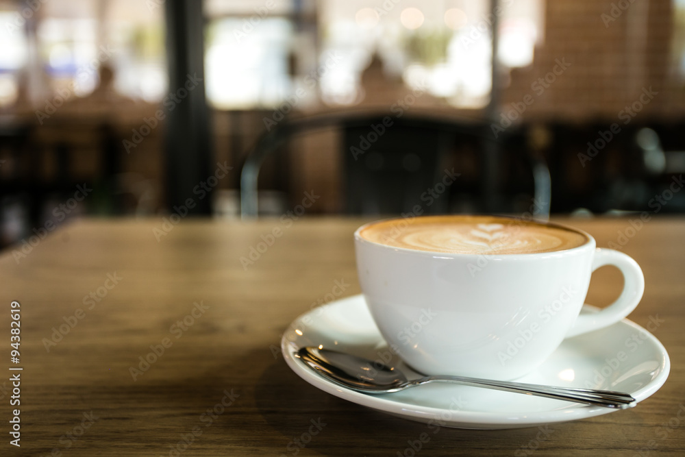 Hot art Latte Coffee in a cup on wooden table and Coffee shop bl Hot art Latte Coffee in a cup on wooden table and Coffee shop bl