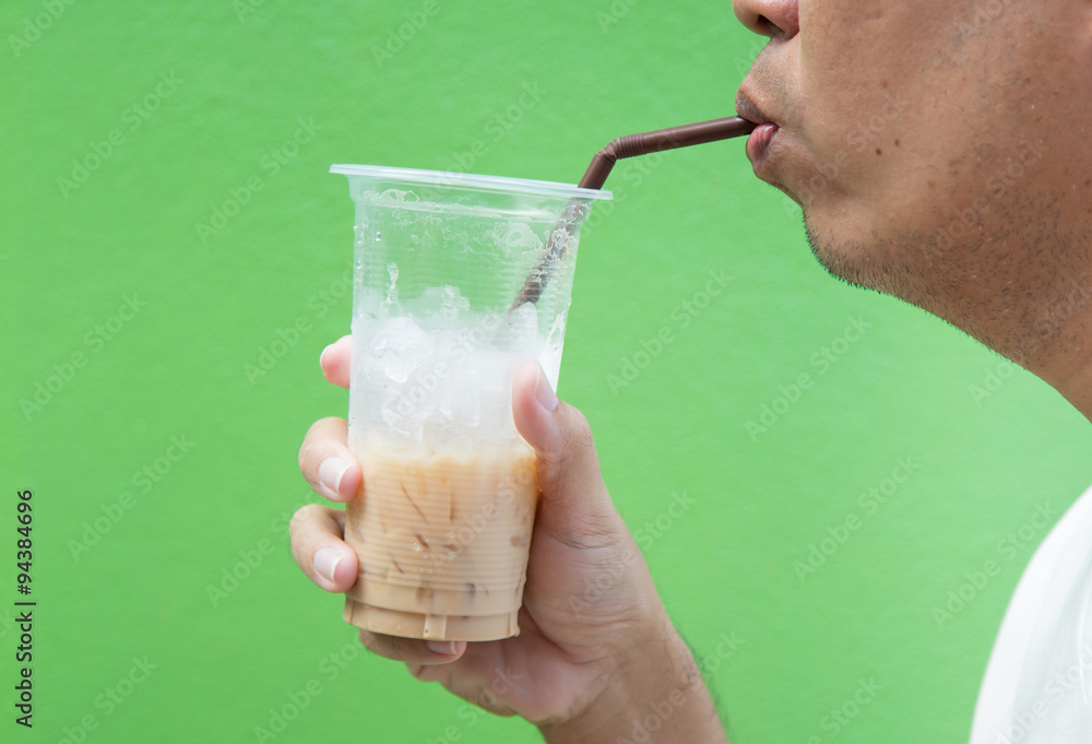 An unidentified man drinking iced coffee An unidentified man drinking iced coffee
