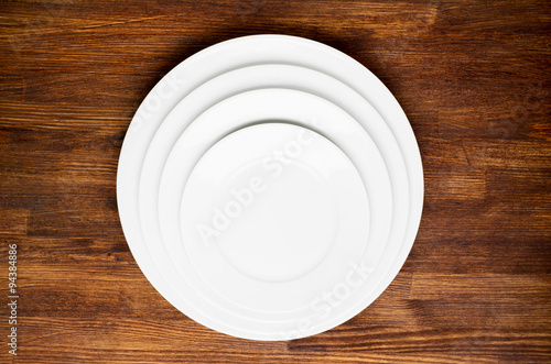 Empty white plates on wooden table