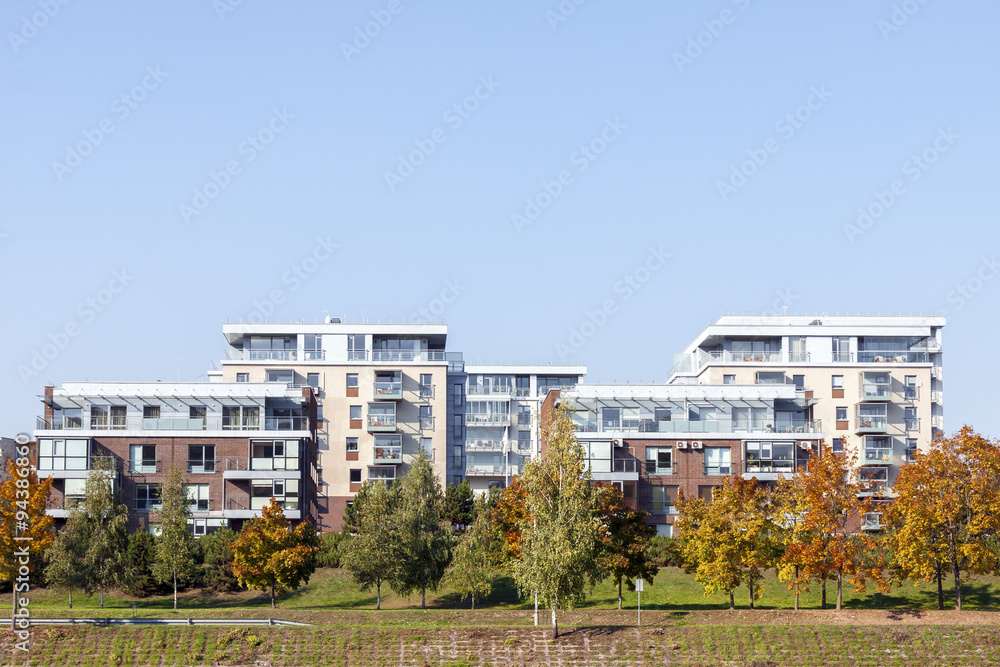 Modern residential apartment houses surrounded by yellow trees at autumn