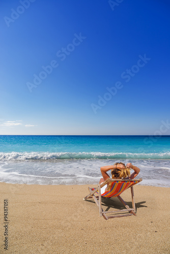 Obraz na plátne Woman on a sun lounger at the beach