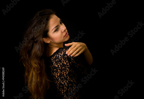 Portrait of beautiful young girl in black against dark background