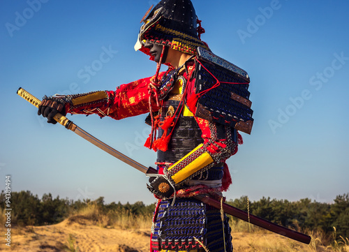 Samurai in a field in ancient armor pulls the sword attack