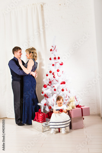 Christmas family of three  persons and fir tree with gift boxes 