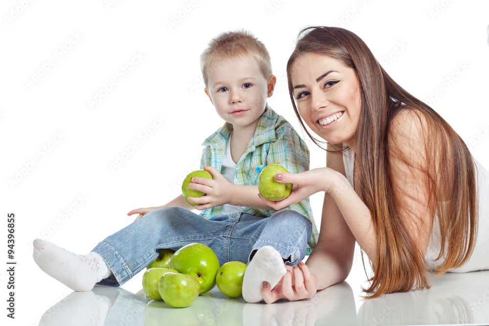 Fototapeta premium Mother with son are eating apples in studio
