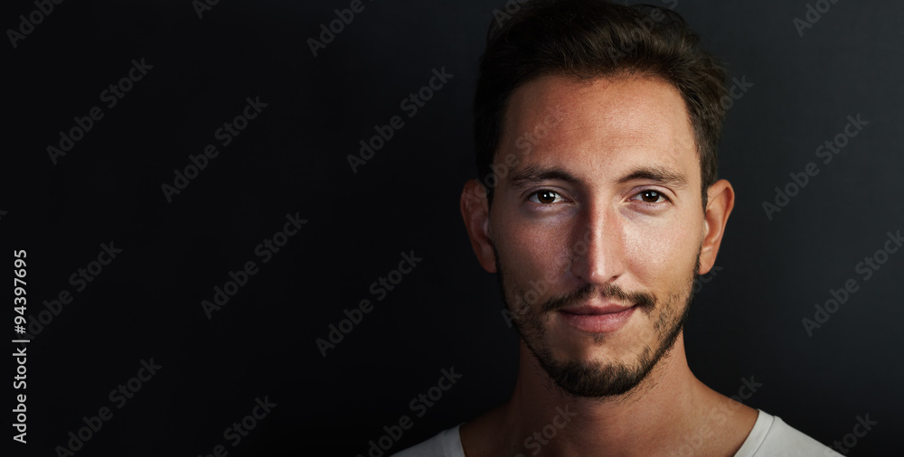 Portrait of cute young man wearing white tshirt and looking at the camera. Wide Portrait of cute young man wearing white tshirt and looking at the camera. Wide