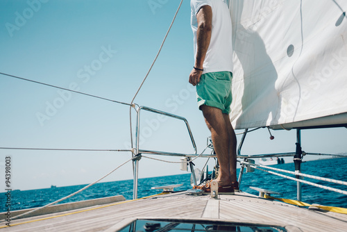 View of young man standing on the nose yacht © SFIO CRACHO