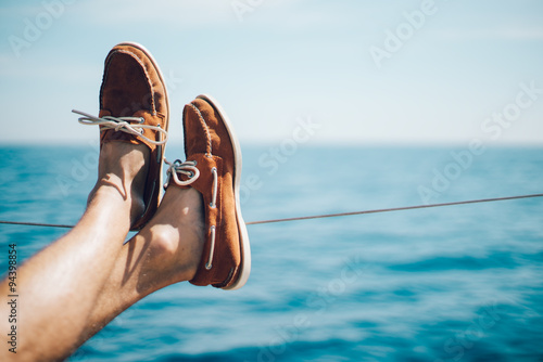 Photo of man legs on the yacht and wearing boat shoes © SFIO CRACHO