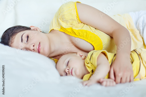 Happy mother with her baby in the morning bed