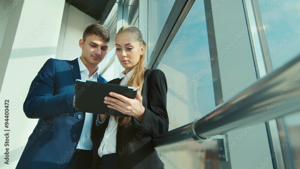Business meeting business partners. Man and woman discussing data screen tablet Business meeting business partners. Man and woman discussing data screen tablet