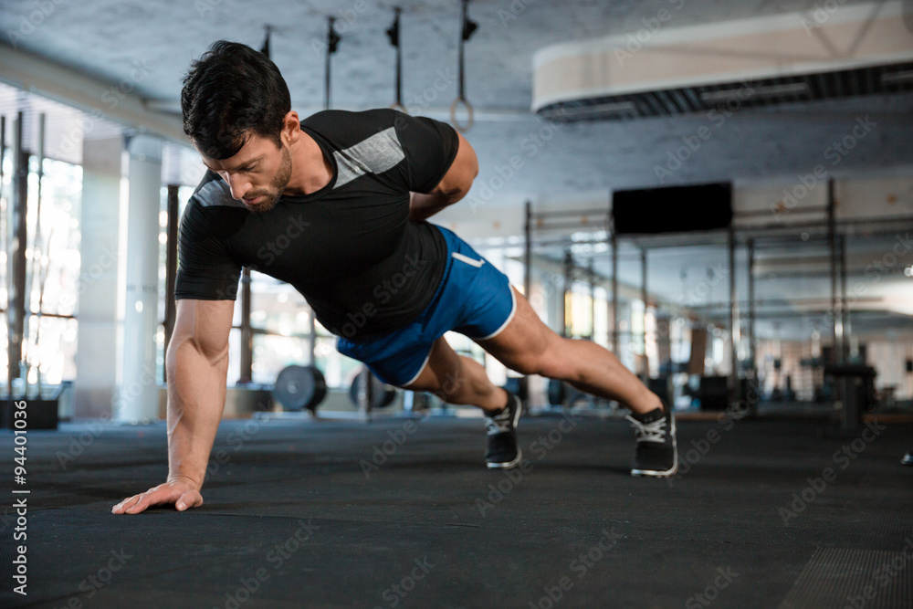 Athlet doing one hand push-ups Athlet doing one hand push-ups