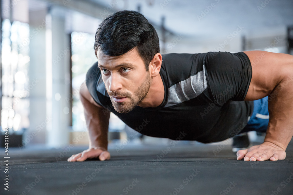 Naklejka premium Man doing push ups in gym