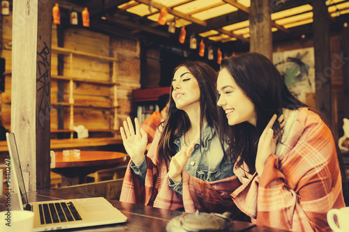 two girls watching something in laptop