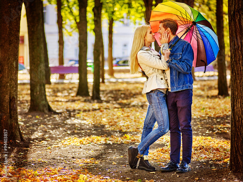 Loving couple full height on a date kissing under umbrella. © Gennadiy Poznyakov