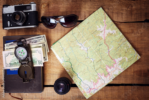 travel equipment - map, backpack, vintage camera, sunglasses, compass, passport and money